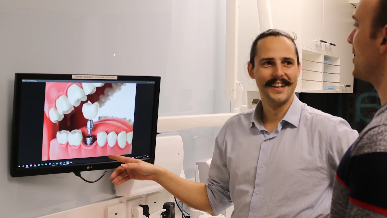 Dr Ryan Moldrich explaining a dental implant procedure to a patient